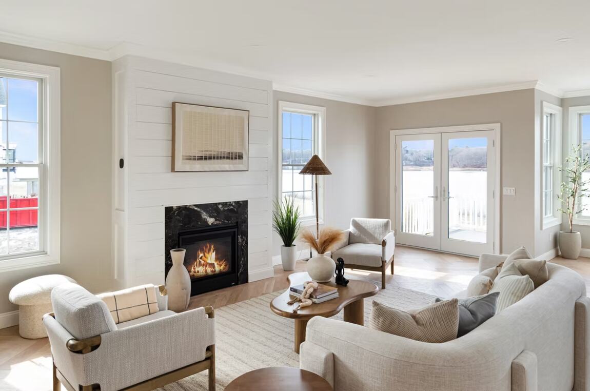 Living room with a gas fireplace and French doors to the water